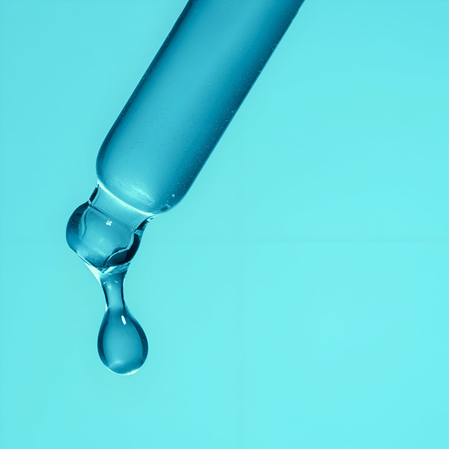 A close up image of a drop of Nano colloidal copper liquid copper supplement dripping off a glass dropper