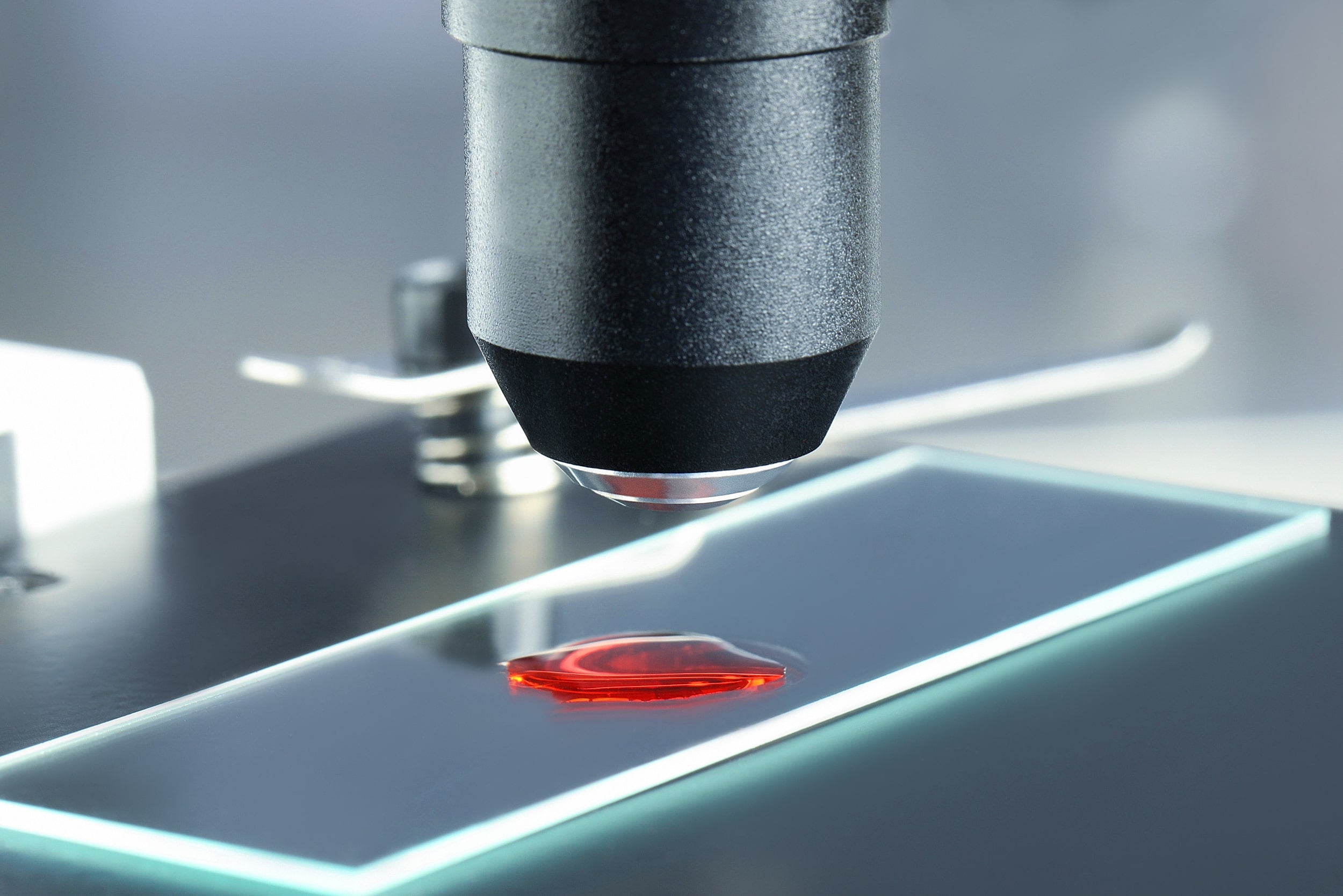 A sample of Nano 24K Ruby Red Colloidal Gold being examined on a glass microscope slide 