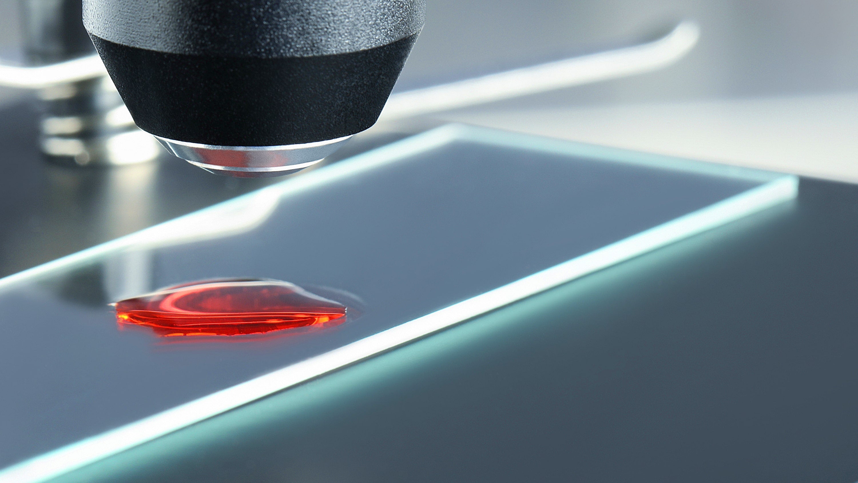 Nano 24K Ruby Red Colloidal Gold being examined on a glass microscope slide 