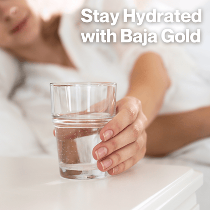 Woman staying hydrated with a glass of water mixed with Nano Baja Gold Organic Mineral Sea Salt