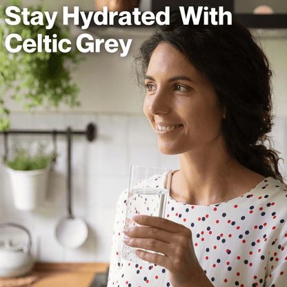 A middle aged woman enjoying a glass of water mixed with Nano Celtic Grey French Organic Mineral Coarse Sea Salt for hydration 